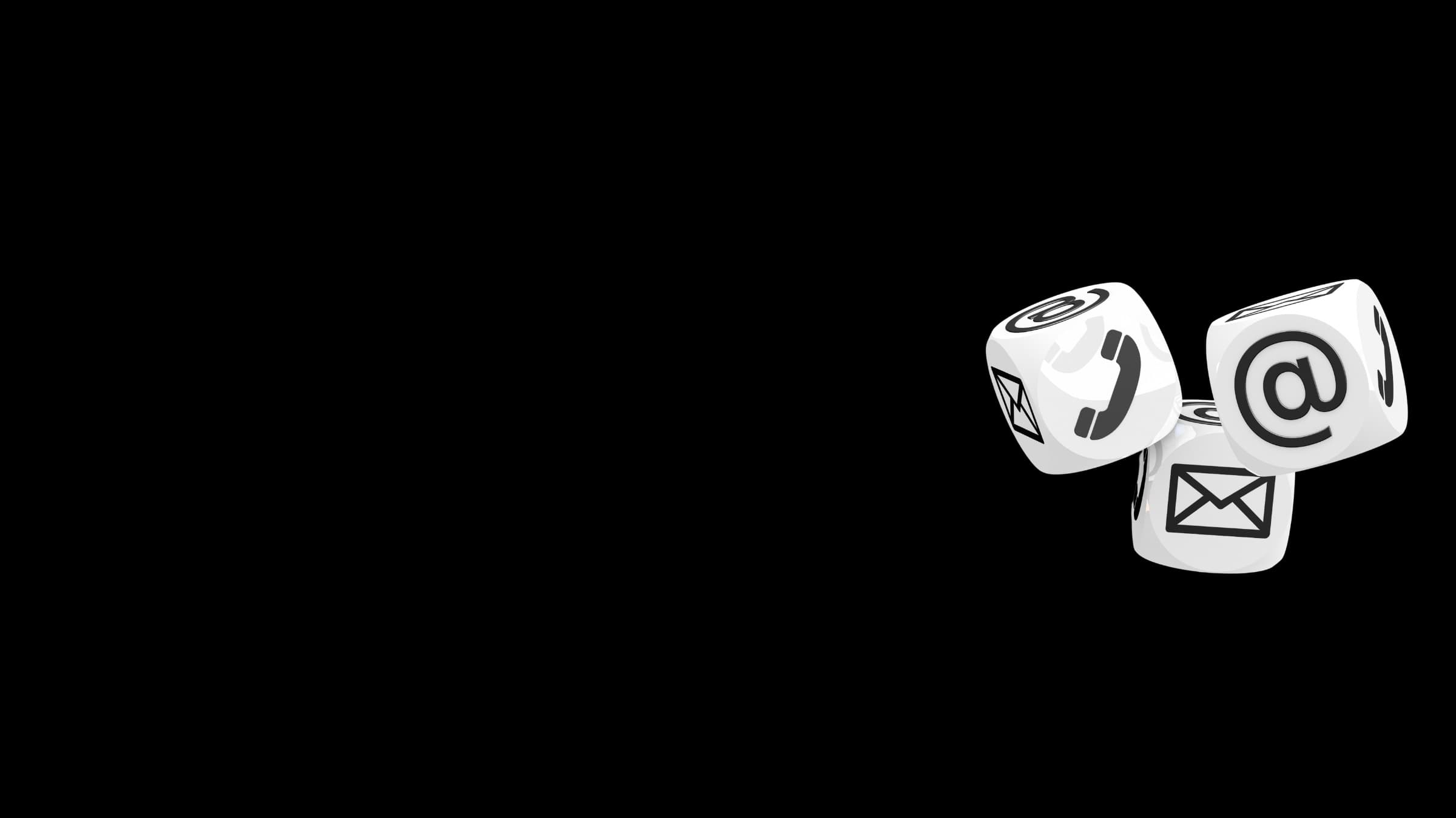 Three white cubes tumbling against a black background, their faces carrying an at sign, a telephone handset and an envelope.